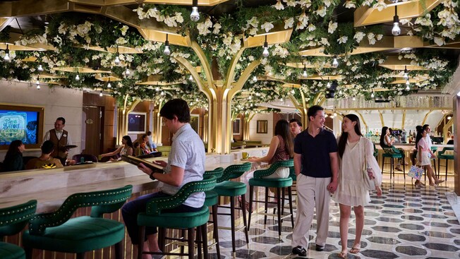 Guests enjoying coffee together at Tiana’s Bayou Lounge aboard the Disney Adventure cruise ship
