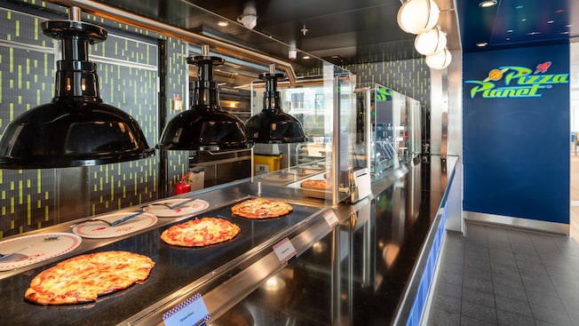 Tres pizzas grandes bajo calentadores en Pizza Planet en el crucero Disney Adventure Tres pizzas grandes bajo calentadores en Pizza Planet en el crucero Disney Adventure