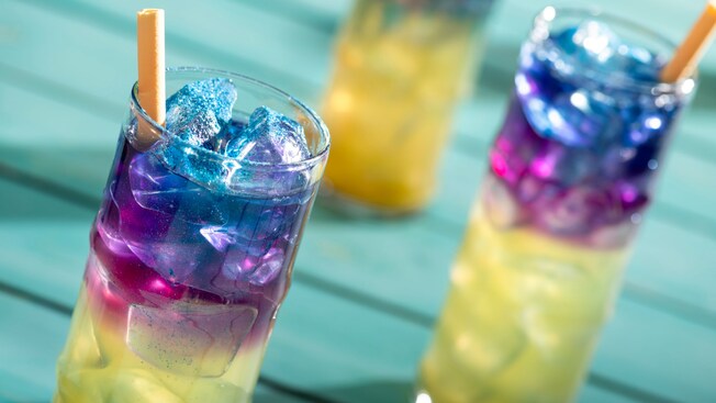 Bebidas combinadas multicolores en una mesa de Spellbound, un salón a bordo del Disney Adventure
