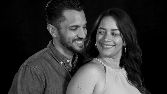 A portrait photo taken at Disney Studio of a couple smiling at each other A portrait photo taken at Disney Studio of a couple smiling at each other