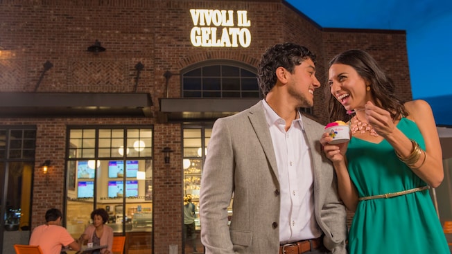 Homem e mulher comendo doces em frente ao Vivoli il Gelato