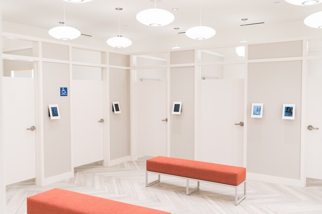 El área de vestidores en Fabletics, con 2 bancos y 5 vestidores individuales