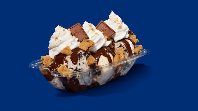 A sundae with vanilla ice cream, hot fudge, whipped cream, chocolate chip cookie crumbles and chocolate squares