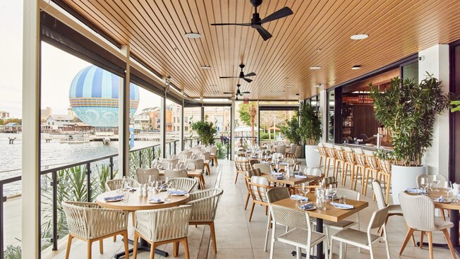 Several restaurant tables arranged on a lakeside patio