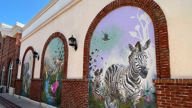 A triptych on a wall at Disney Springs filled with elephants, tigers and zebras