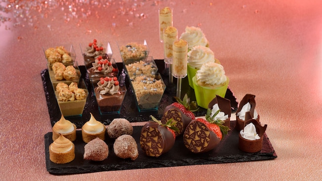A platter of assorted desserts, including chocolate covered strawberries, butterscotch pudding and pastries 