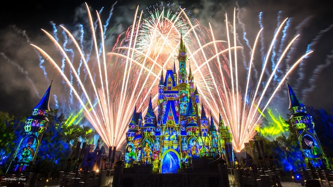 Cinderella Castle transformed with Disney themed projections, as fireworks burst in the night sky