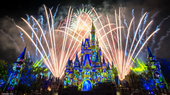 Fireworks burst over Cinderella Castle as lights cover it in a stained glass theme