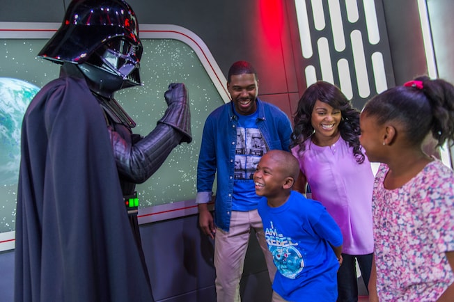 Darth Vader strikes a menacing pose while meeting a family of 4