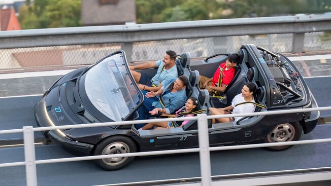 A family of 5 Guests smiling as they ride Test Track at Epcot