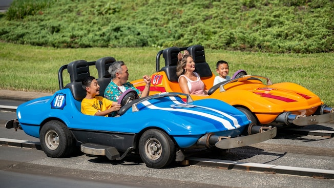 Los Visitantes navegan lado a lado por Tomorrowland Speedway en Magic Kingdom Park