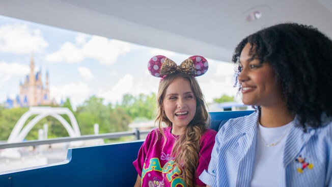 Two Guests riding the Tomorrowland Transit Authority PeopleMover at Magic Kingdom park with views of Cinderella Castle