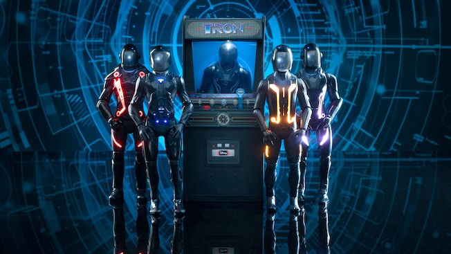 4 TRON inspired action figures beside a TRON themed arcade game