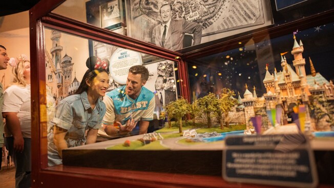 Guests looking at a Cinderella Castle diorama in the Walt Disney Presents gallery at Disney’s Hollywood Studios