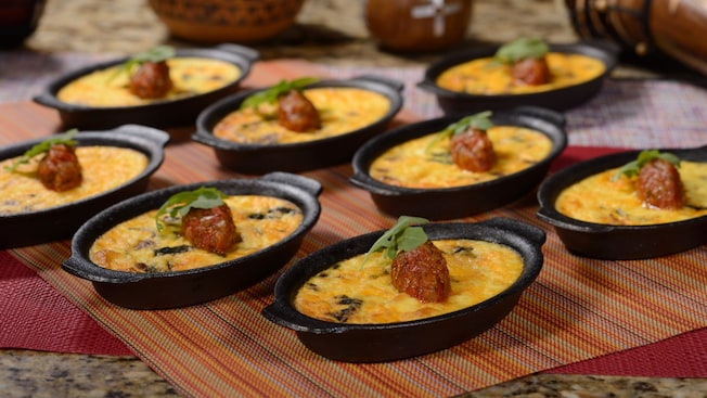 Várias tigelas de ferro fundido com bobotie de peru, um prato assado da África do Sul com carne moída e ovo