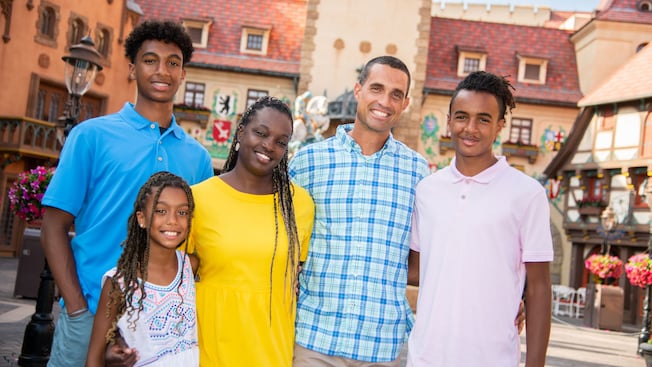 A family of five pose for a photo in a courtyard in the EPCOT World Showcase Germany Pavilion at Walt Disney World Resort