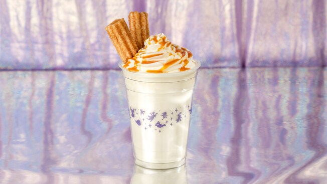 A vanilla shake with caramel sauce and a topping of 2 churro pieces