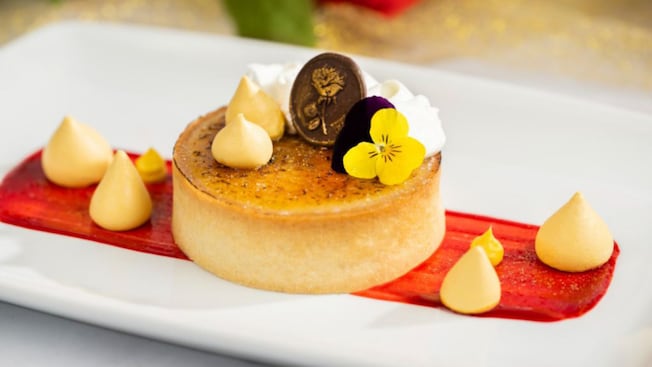 Crème Brûlée topped with edible flowers and a chocolate medallion with a rose on it from Be Our Guest