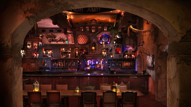 A weathered, arched doorway leads into The Beak and Barrel, a pirate themed tavern at Magic Kingdom park