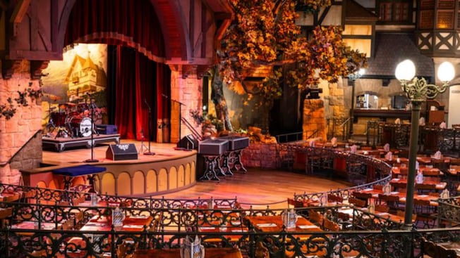 A section of Biergarten Restaurant in Epcot with a stage surrounded by tables and chairs