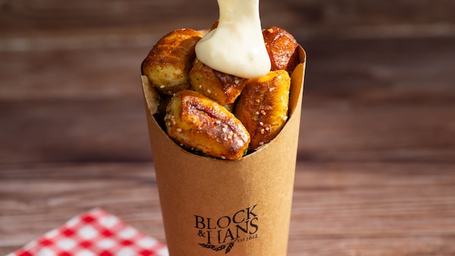 Pretzel Nuggets from Block & Hans being topped with a beer cheese sauce