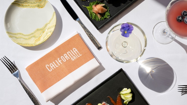 A table setting at California Grill featuring a Surf & Turf Roll, a Blueberry Lemon Drop Martini and a Barbecue American Eel Roll