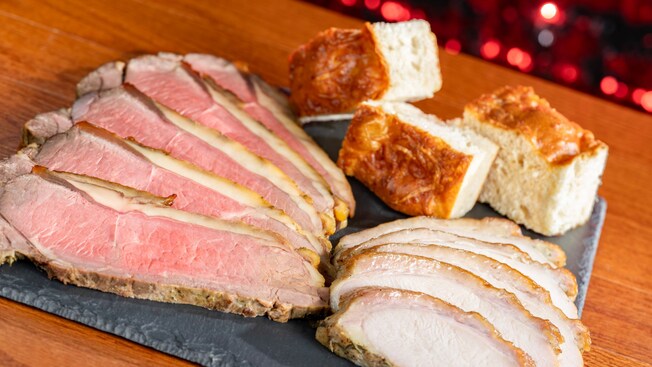 Slices of carved beef and turkey next to pieces of focaccia bread