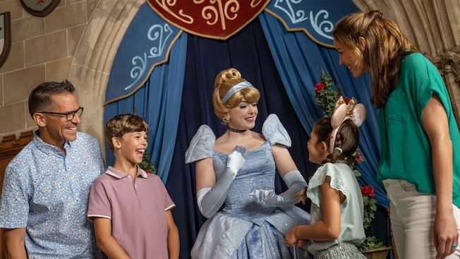 Cinderella talking to a family of 4 in the Grand Hall at Cinderella's Royal Table