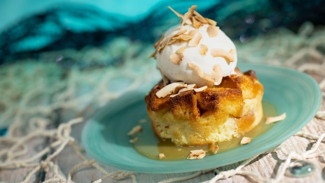 A plate of Pineapple Coconut Bread Pudding with vanilla ice cream, available at Coral Reef Restaurant at Epcot