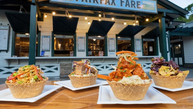 Four protein bowls on plates arranged near the Fairfax Fare stand