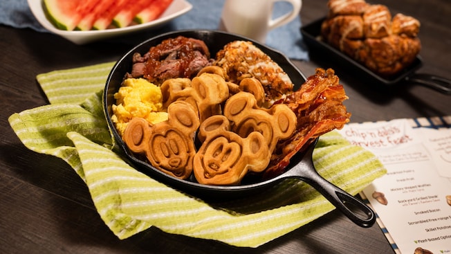 Una sartén con waffles de Mickey, huevos revueltos y tocineta