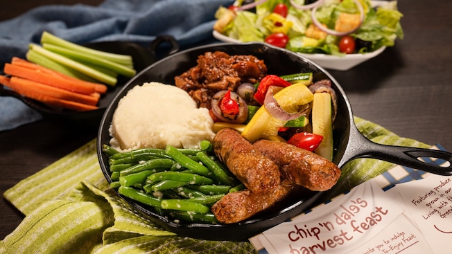 Una sartén con vegetales y una ensalada grande como acompañante