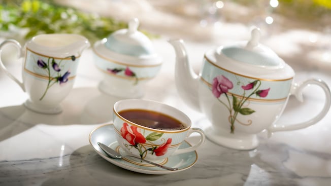 A table set with a teapot, a teacup with saucers and creamer
