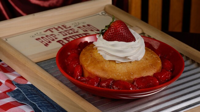 Shortcake de morango em uma tigela em cima de uma placa em tábua de lavar roupa com os dizeres The Hoop Dee Doo Revue