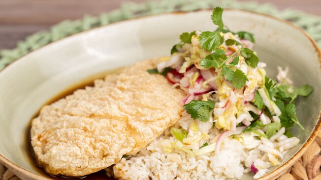 A plate of crispy fried chicken with chili soy glaze, jasmine rice and pickled vegetable slaw