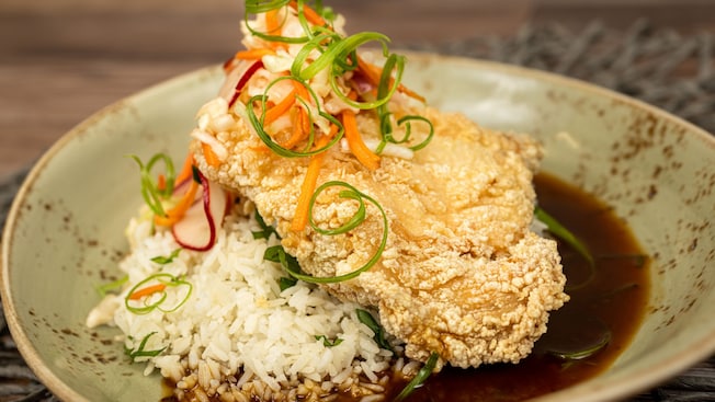 A plate of crispy fried chicken with chili soy glaze, jasmine rice and pickled vegetable slaw