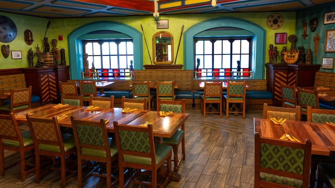 A dining room decorated with carved wooden statues, masks and spears at the Jungle Navigation Company Limited Skipper Canteen