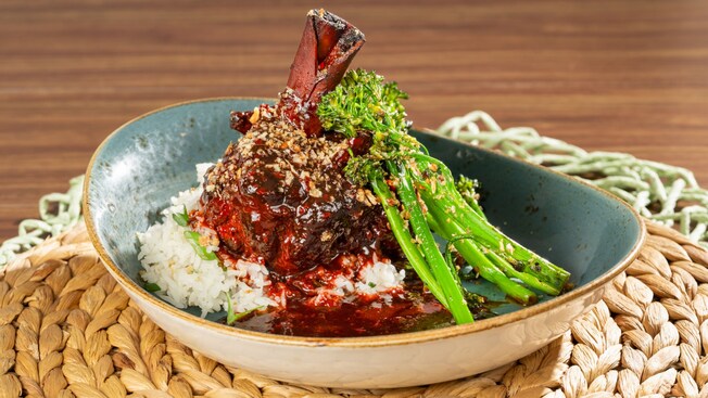 A glazed leg of duck on top of a bed of rice with vegetables, at LTD Skipper Canteen