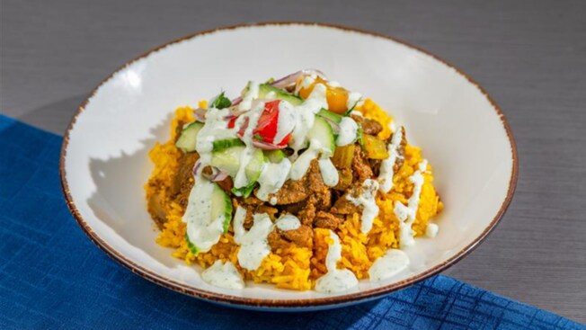 A beef bowl featuring rice, cucumber and tzatziki sauce
