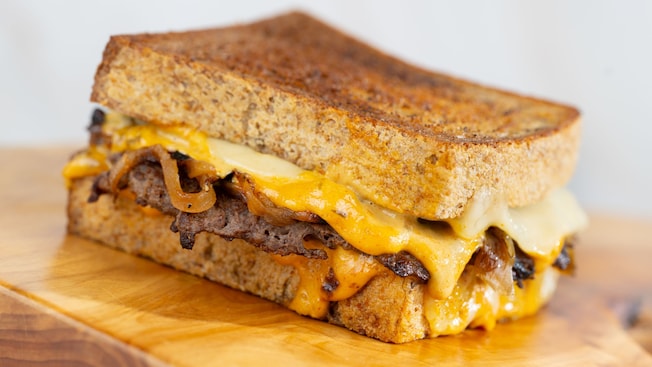 A grilled cheese sandwich with a smashed beef patty, melted cheese and caramelized onions