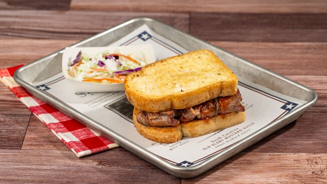 Un sándwich de barbacoa servido con ensalada de col en una bandeja 
