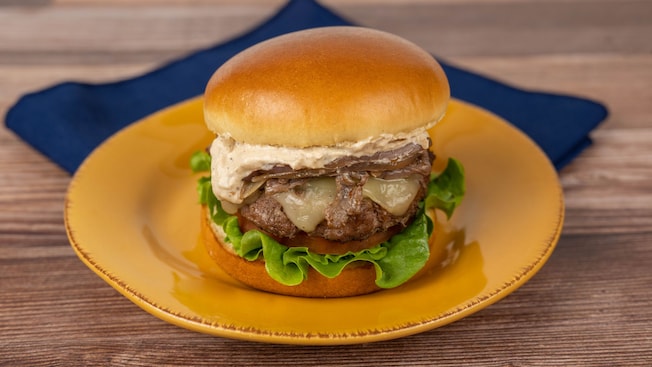 A beef burger topped with shaved beef, swiss cheese and french onion aioli on a plate from Riverside Mill Food Court