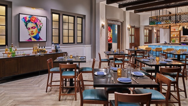 Bar e lounge do Rosa Mexicano, com decoração moderna e obras de arte representando a artista Frida Kahlo na parede