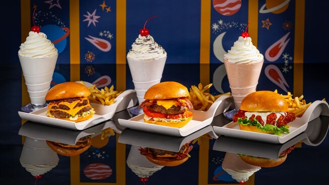 A trio of sandwich combos, featuring 2 burgers and a chicken sandwich, served with french fries and a milkshake