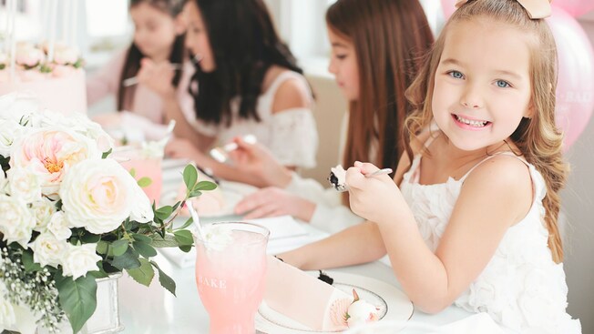Four young girls seated at a table enjoy a tasty treat