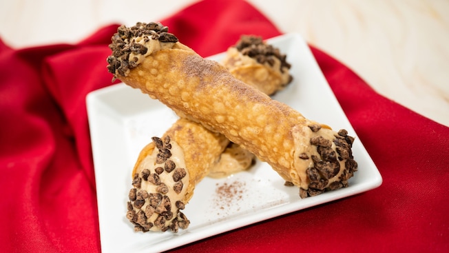 2 cannolis on a plate with chocolate chips
