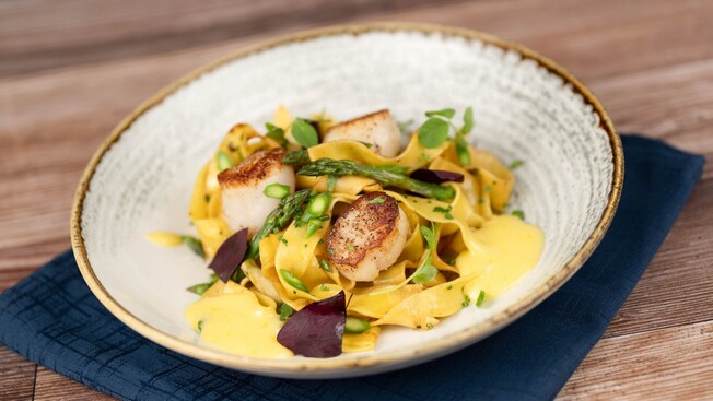 A bowl of Pappardelle Scallop Pasta with caramelized scallops, asparagus and truffle sauce