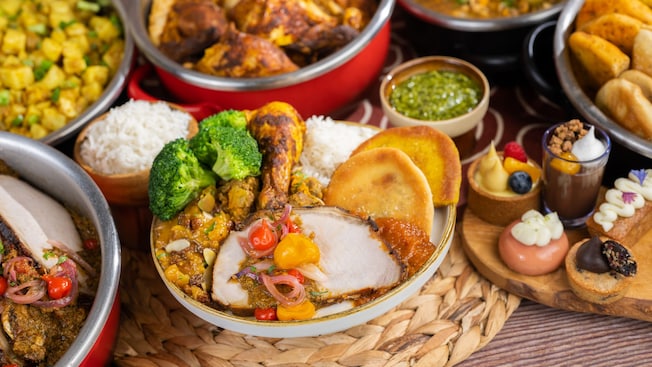Un bufet con carnes especiadas, arroz, vegetales, panes planos y postres 