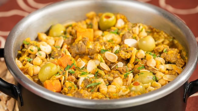 Un estofado de carne y garbanzos con aceitunas y vegetales en una olla