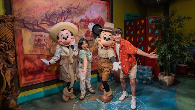 Visitantes posando para una foto con Mickey Mouse y Minnie Mouse con vestimenta de safari en Adventurers Outpost, en Disney's Animal Kingdom Theme Park